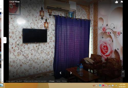 a living room with a television on a wall at Grace Hotel in Gobindpur