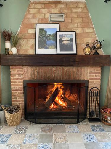 a fireplace with two pictures on top of it at Casa Rural La Higuera in Ruidera