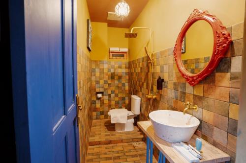 a bathroom with a sink and a mirror at Por Aqui Stay & Dine in Yogyakarta