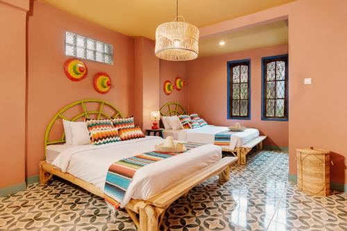 En eller flere senge i et værelse på Por Aqui Stay & Dine