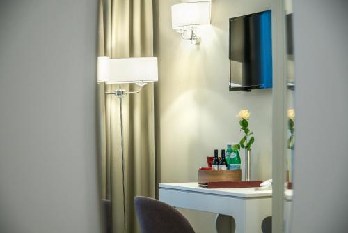 a table with a lamp and a vase on it at Ratonda Centrum Hotels in Vilnius