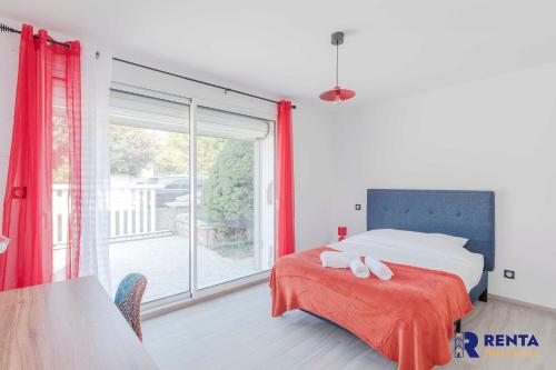 a bedroom with a bed and a large window at La Villa Rosa Wifi Jardin Barbecue in Béziers