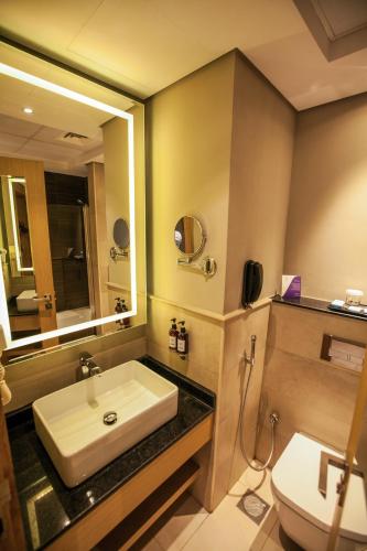 a bathroom with a sink and a toilet at Flora Inn Hotel Dubai Airport in Dubai