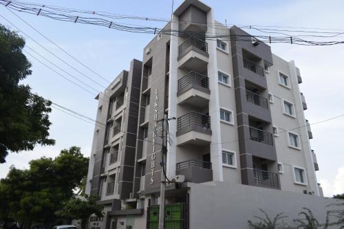 a tall white building with lots of windows at Viswa Residency by Azalea in Madurai
