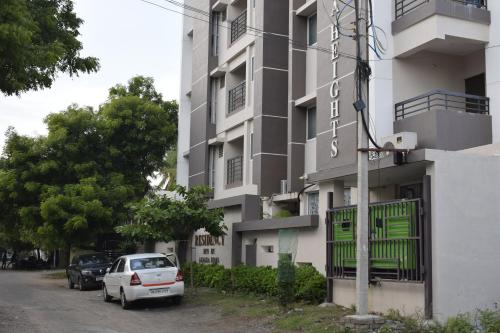a white car parked in front of a building at Viswa Residency by Azalea in Madurai
