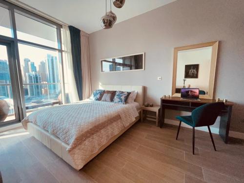 a bedroom with a bed and a desk and a window at Luxury apartment on the metro facing Dubai Marina in Dubai