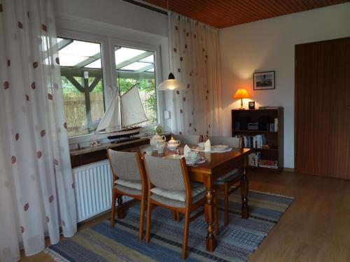 jadalnia ze stołem i krzesłami oraz oknem w obiekcie Ferienwohnung Martens w mieście Fockbek