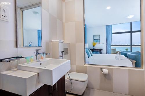 a bathroom with a sink and a toilet and a mirror at bnbmehomes - Rare Find on the Palm Jumeirah - 100 in Dubai