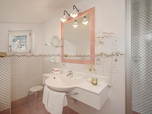 a white bathroom with a sink and a mirror at Aparthotel Stacherhof in Fügen