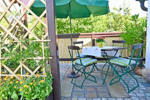 a table and chairs under an umbrella on a patio at Ferienwohnung Tammer in Schirgiswalde