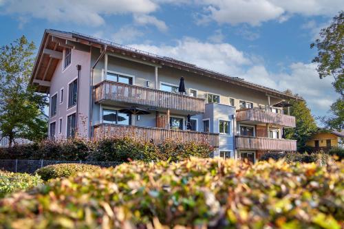 a pink building with a balcony and trees at City Suites Murnau in Murnau am Staffelsee