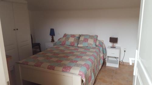 une chambre avec un lit avec une couette dessus dans l'établissement LES LAURIERS, au Castellet