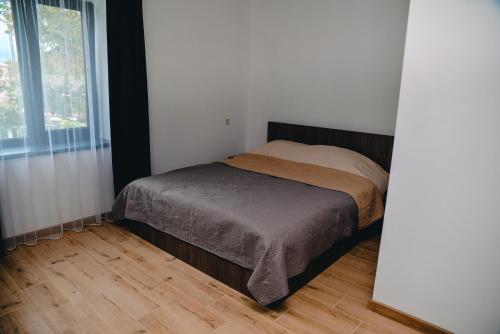 een bed in een slaapkamer met een houten vloer bij Four Rooms Apartments in Tsjerkasi