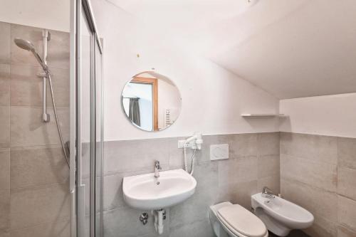 La salle de bains est pourvue d'un lavabo, de toilettes et d'un miroir. dans l'établissement Texel Apartments, à Senales
