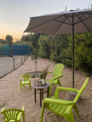 a table and chairs with an umbrella on the beach at Casa Rural La Higuera in Ruidera