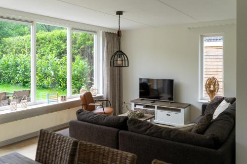 a living room with two couches and a television at Kom in de Bedstee Magie! in Winterswijk