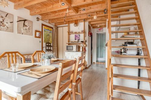 - une cuisine et une salle à manger avec une table et une échelle dans l'établissement Le Lutin, à La Bresse