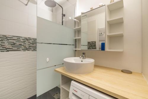 a white bathroom with a sink and a shower at Le Saphir in Branville