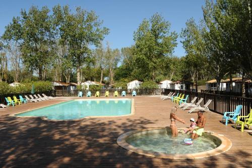 a family playing in a swimming pool at a resort at Camping La Dune in Vias