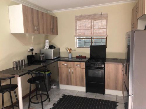 a kitchen with wooden cabinets and a black stove top oven at Cozy One bedroom garden cottage in Roodepoort