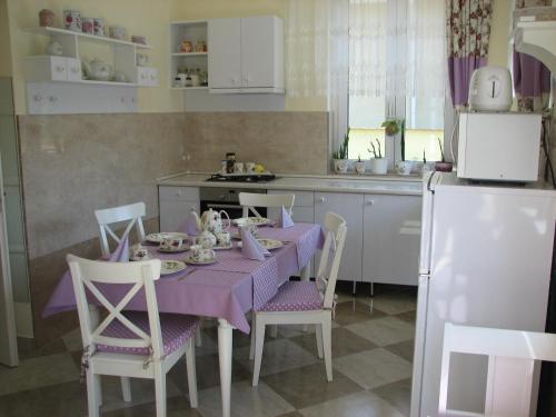 a kitchen with a table with a purple table cloth at Aranyosház-Vendégház in Budapest