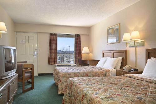 una camera d'albergo con due letti e una televisione di Days Inn by Wyndham Apple Valley Pigeon Forge/Sevierville a Pigeon Forge