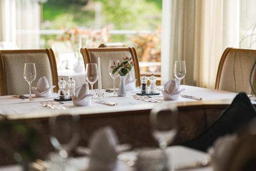 a table with wine glasses and flowers on it at Hotel Theresia in San Leonardo in Passiria