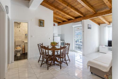 a kitchen and dining room with a table and chairs at Holiday Home Dijamant in Kučiće