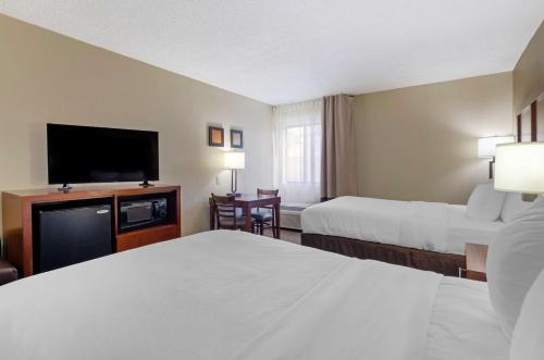 a hotel room with two beds and a flat screen tv at Comfort Inn in Bluefield