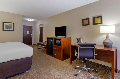 a hotel room with a bed and a desk with a computer at Comfort Inn in Bluefield
