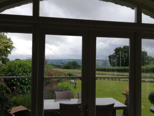 uma janela com vista para um jardim com uma mesa e cadeiras em Rusling House em Bristol