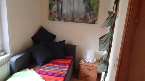 a small room with a bed and a night stand at Ferienwohnung Alte Dorfschule in Witzenhausen