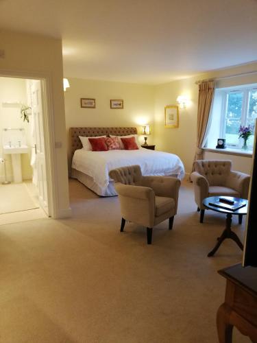 um quarto de hotel com uma cama e duas cadeiras em Rusling House em Bristol