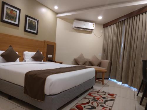 a hotel room with a bed and a couch at HOTEL NILADRI PREMIUM in Puri