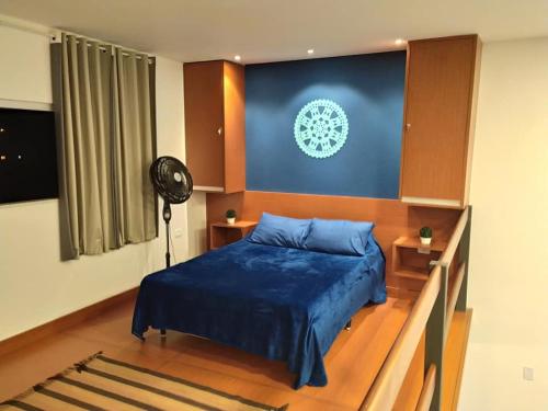een slaapkamer met een blauw bed en een ventilator bij Lofyt em Paraty in Paraty