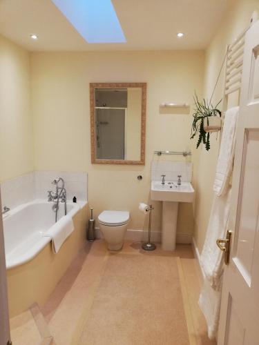 uma casa de banho com uma banheira, um WC e um lavatório. em Rusling House em Bristol