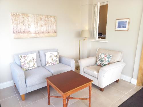 a living room with two chairs and a table at Trelawne Hotel in Falmouth