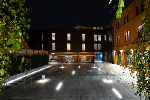 un patio vacío por la noche con luces en Hotel 1231 en Toruń