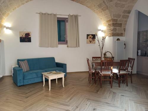 sala de estar con sofá azul y mesa en La Casa Di Chia, en Trepuzzi