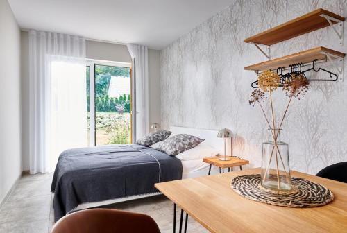 a bedroom with a bed and a table with a vase at Bei Meyers - Leipzig Neue Messe in Leipzig