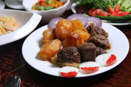 a plate of food with meat and vegetables on a table at HUMSON BULOQ SANATORIUM in Khumson
