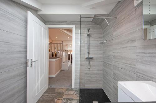 baño con ducha a ras de suelo y puerta de cristal en Premium Studio Apt B in Oban Town, en Oban