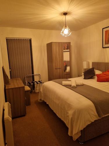 a hotel room with two beds and a chandelier at The Symphony Apartment in Liverpool