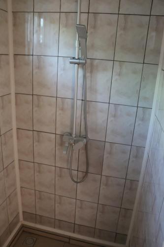 una ducha con una manguera en una pared de azulejos en Dubbel woonhuis Selderiestraat Paramaribo, en Paramaribo