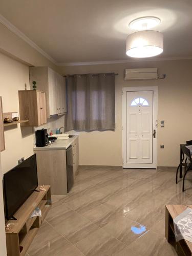 a room with a kitchen with a door and a table at John's apartment's near Athens Airport!! in Spáta
