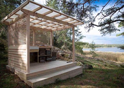 a wooden pergola sitting next to a body of water at Glamping in the Trosa Archipelago in Trosa