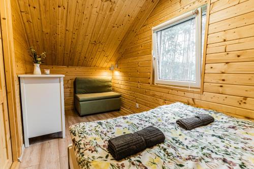 A bed or beds in a room at Słoneczny Zagajnik-domek na skraju lasu, Roztocze, Zwierzyniec