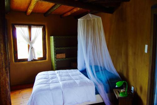1 dormitorio con 1 cama con mosquitera en Malva Rosa Relax La Juanita, en José Ignacio