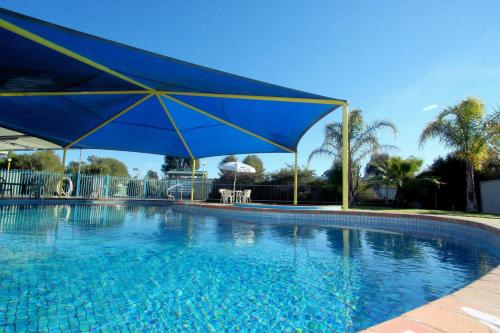 a large blue swimming pool with a blue umbrella at BIG4 Shepparton Park Lane Holiday Park in Shepparton