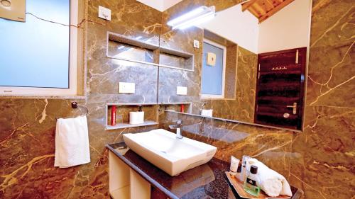 y baño con lavabo y espejo. en Vibhasa-Dhaulagiri Room in Adventure Bliss Villa Where Scenic Views Meet BBQ and Bonfire Delights en Rāmgarh